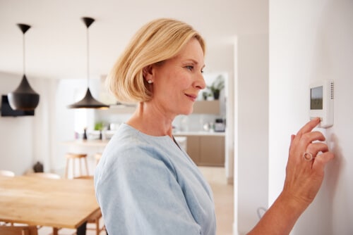 Woman using thermostat