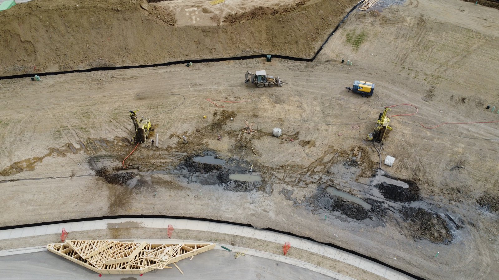Aerial view of two Dandelion drill rigs boring geothermal wells on a Lennar homesite